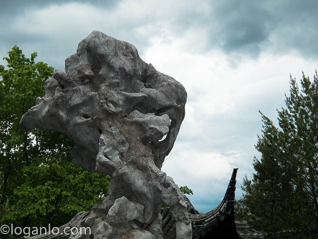 Boulder against cloudy blue sky