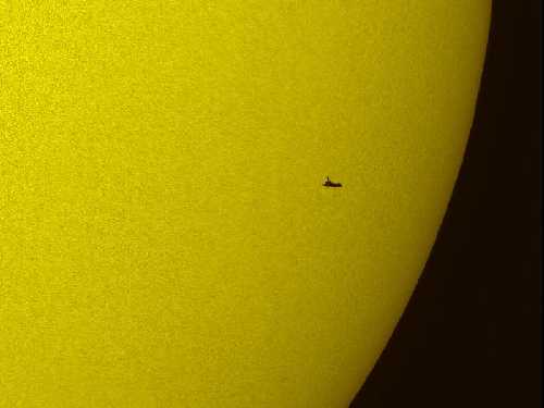 The shuttle atlantis against the sun - copyright NASA